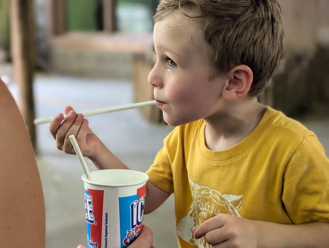 A child enjoying a frozen treat from a cup